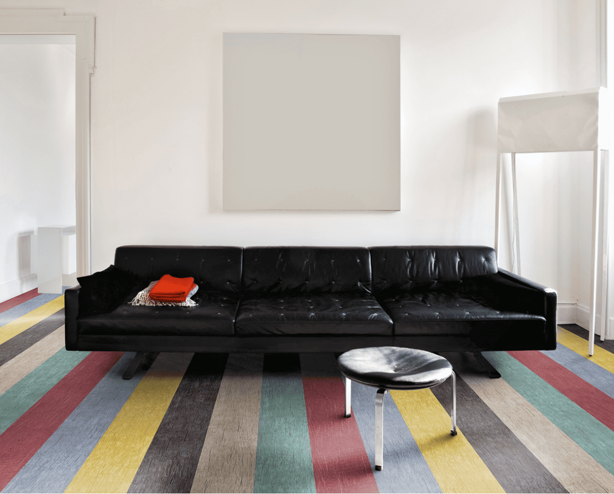 Schwarze Couch auf bunt gestreiftem Teppich