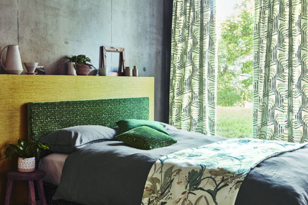 Ein in grün gehaltenes Schlafzimmer mit viel Stoff. 